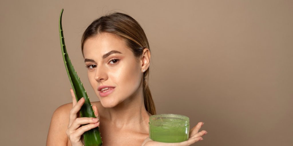 Une jeune femme qui prend soin de sa peau avec de l’aloe vera 