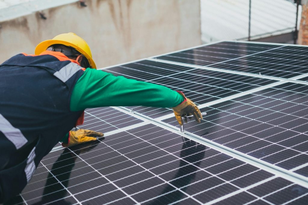 Technicien installant des panneaux solaires pour une solution d’énergie renouvelable accessible 