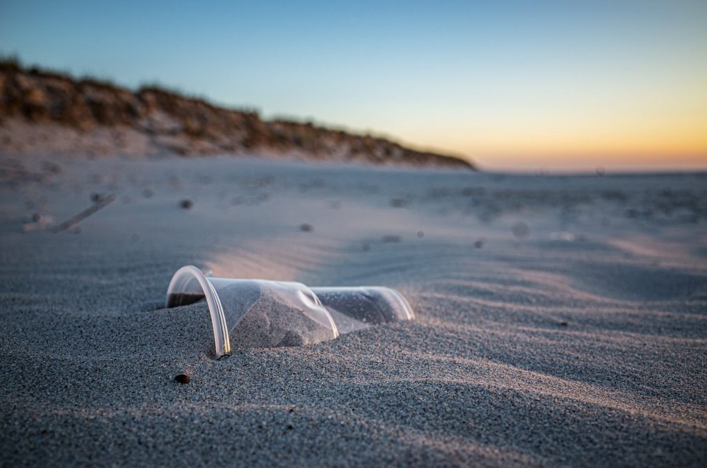 Un verre en plastique usage jeté sur la plage