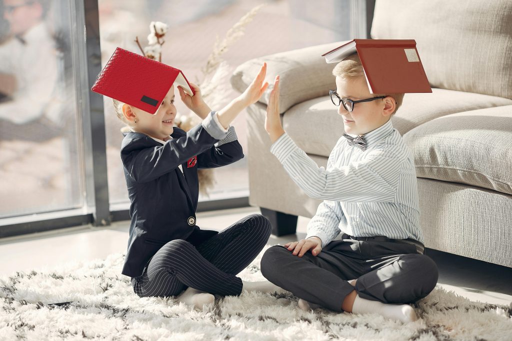 Deux enfants jouant avec des livres sur leur tete