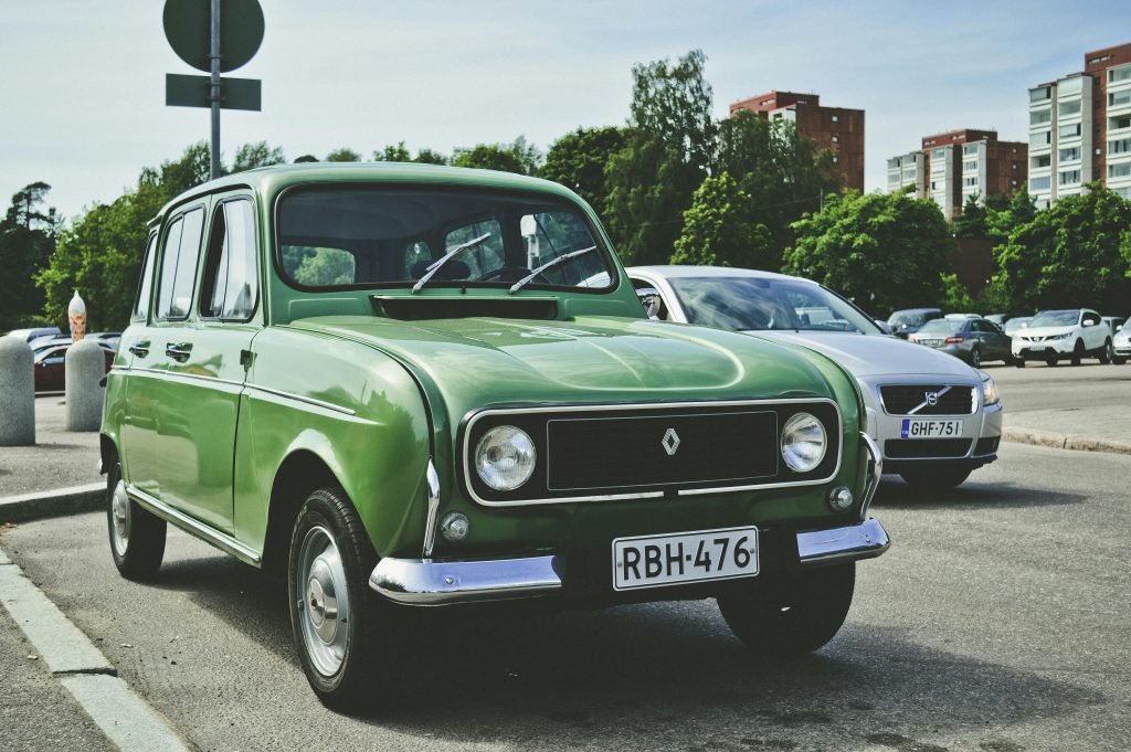 Une Renault 4 verte garee sur un parking